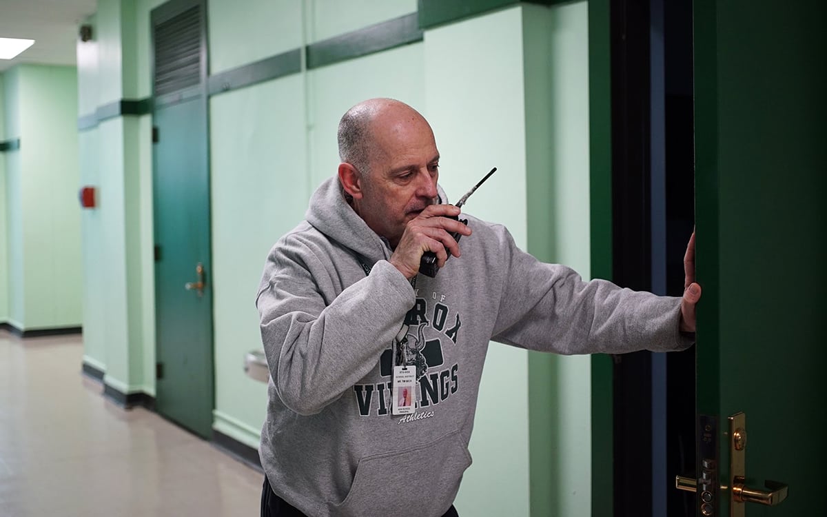 Sto-Rox Junior-Senior High School Principal Tim Beck communicates via handheld radio in a school hallway. (Photo by Ryan Loew/PublicSource)