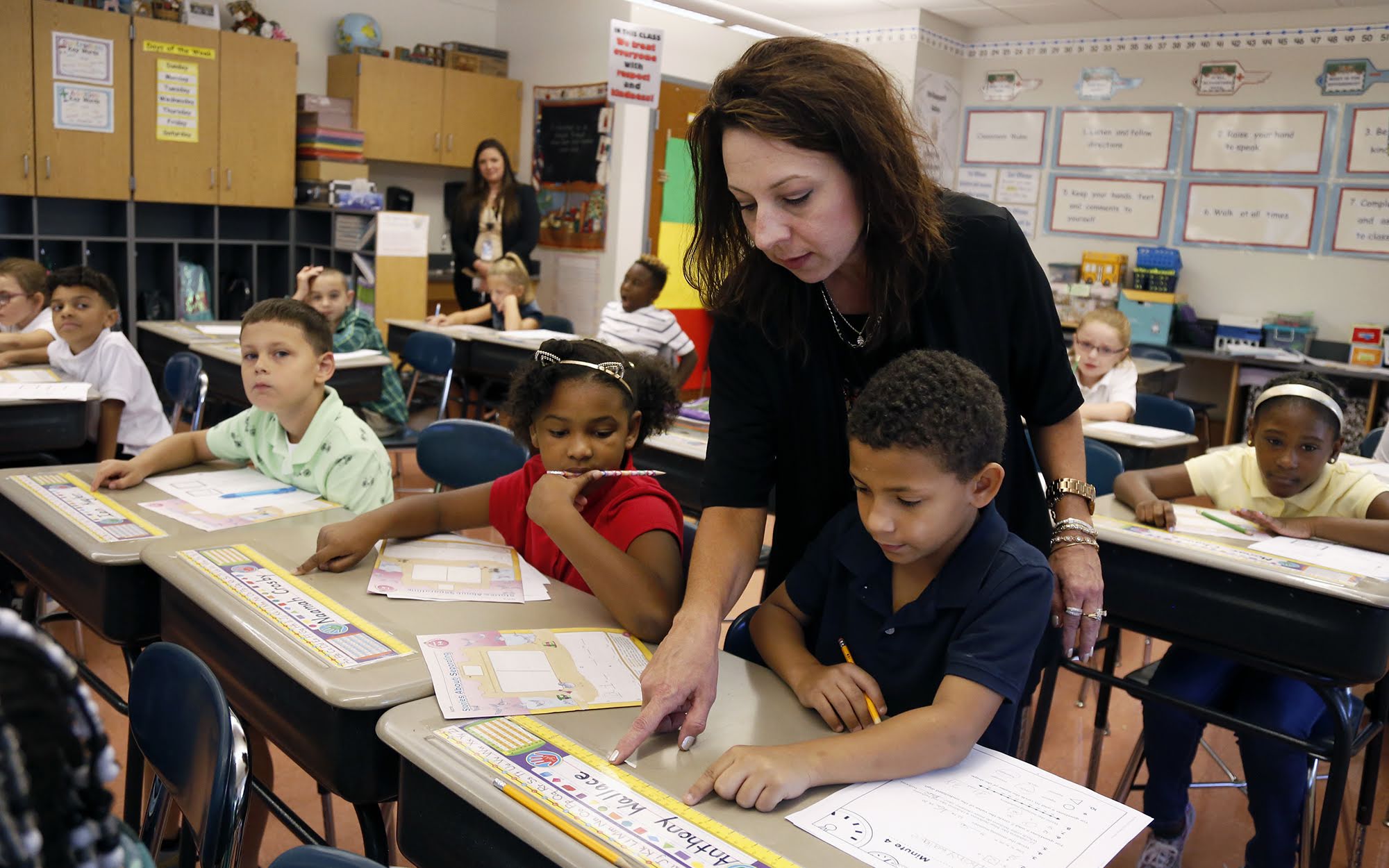 Yvonne Tutera, a second-grade teacher at Francis McClure Elementary in the the McKeesport Area School District, goes over a math lesson with student Anthony Wallace on Aug. 29.