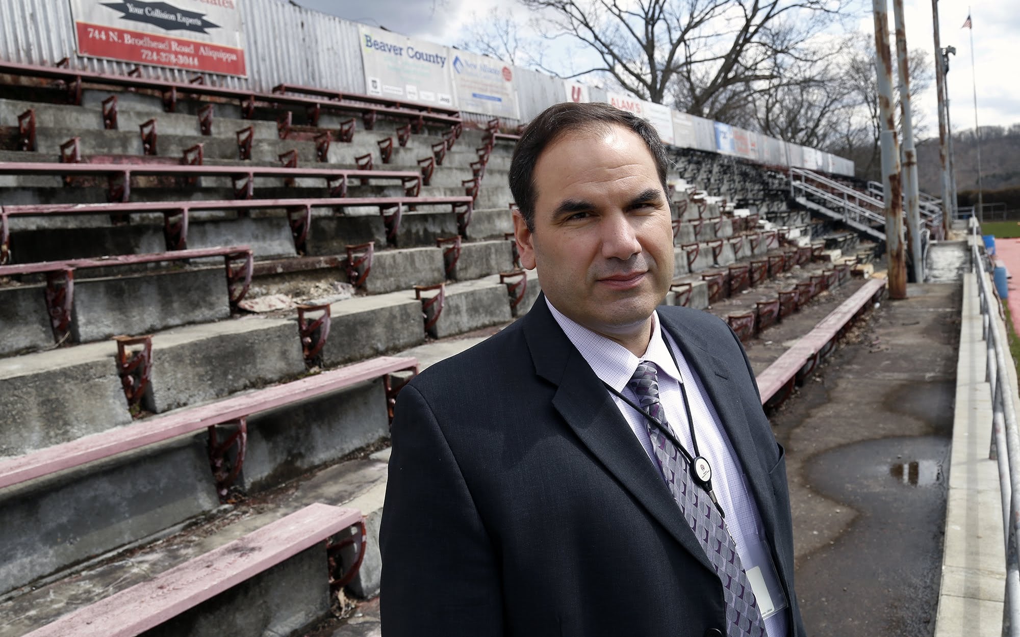 Aliquippa Superintendent Peter Carbone is photographed in the visitors bleachers at Aliquippa Junior/Senior High School's football field. The field is in such poor shape that the visitors bleachers have been permanently closed, the grass field is rocky and rutted and the fieldhouse locker room is dark, dirty and in disrepair.